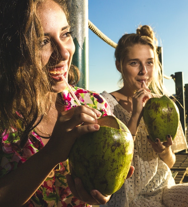 Jenter drikker kokosnøttvann ved Rio de Janeiro.