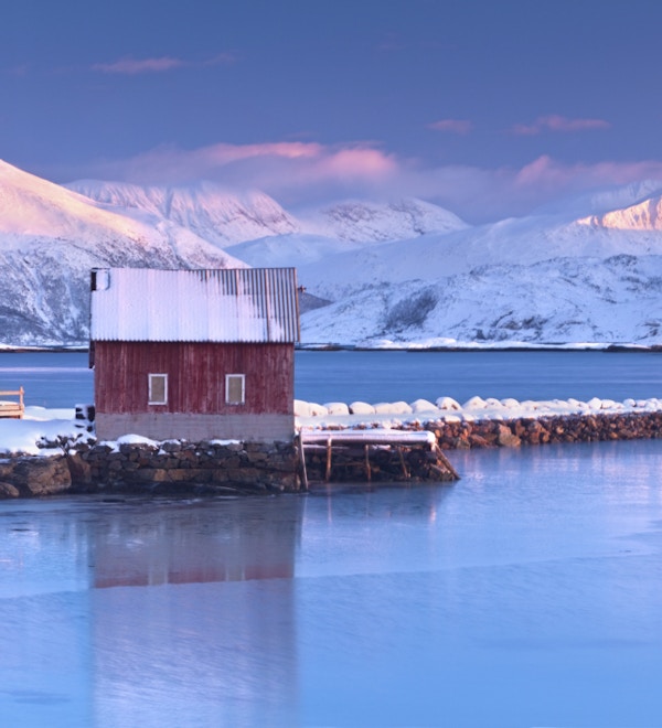 To rorbuer (fiskerhytter) på bredden av en vakker fjord nær Troms, Norge.