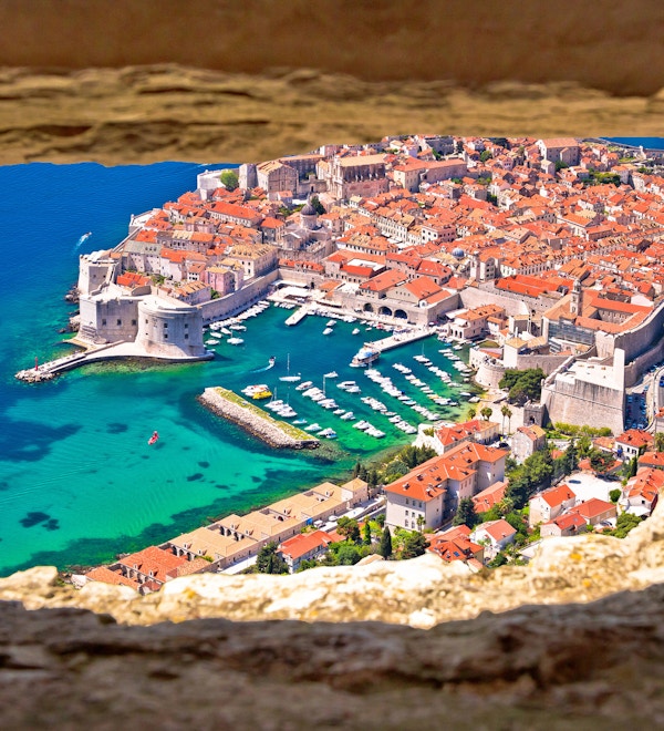 Dubrovnik historiske by- og havneutsikt gjennom steinvinduet fra Srd-bakken, Dalmatia-regionen i Kroatia