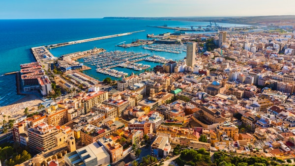 Panoramautsikt over Alicante med sjø, havn og hus.