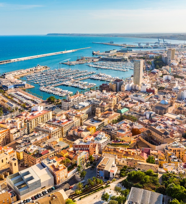 Panoramautsikt over Alicante med sjø, havn og hus.