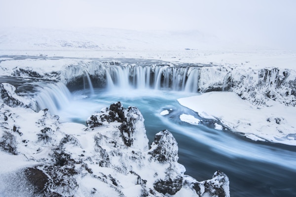 Det vakre fossefallet Godafoss på Island, dekket i snø, lang eksponering