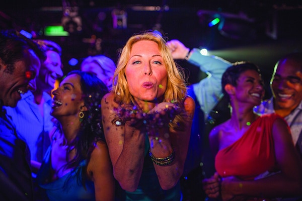 Dame slenger kyss på dansegulvet på nattklubb.