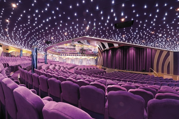 Stor teatersal med lilla stoler, tak med små lys som ligner stjerner og en flott scene