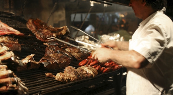 Argentinsk kokk som griller kjøtt