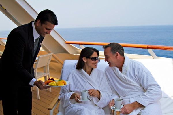 Par i egen suite får servering på privat balkong av velkledd butler