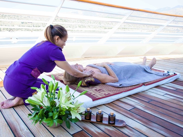 Kvinne får massasje på dekk på yacht.