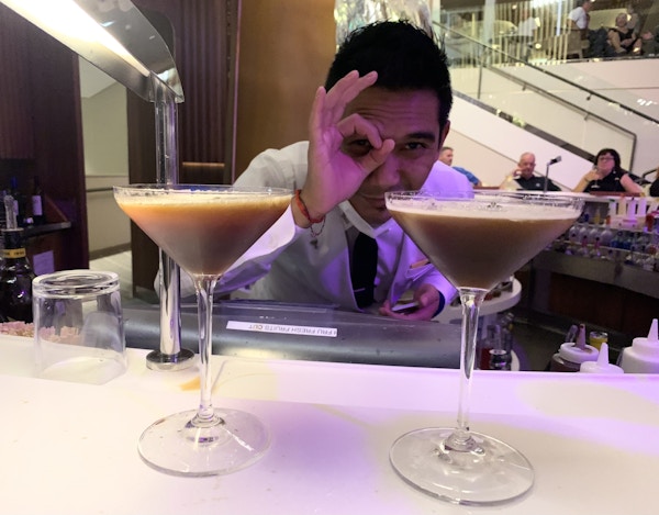 To martiniglass med en bartender bak.
