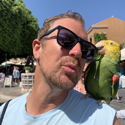 Mann med papegøye på skuldra.