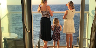 Mor og to døtre fotografert bakfra på balkong fra suite.