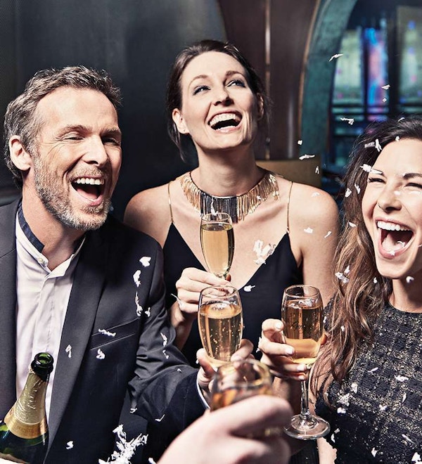 Mennesker feirer med champagne og smiler