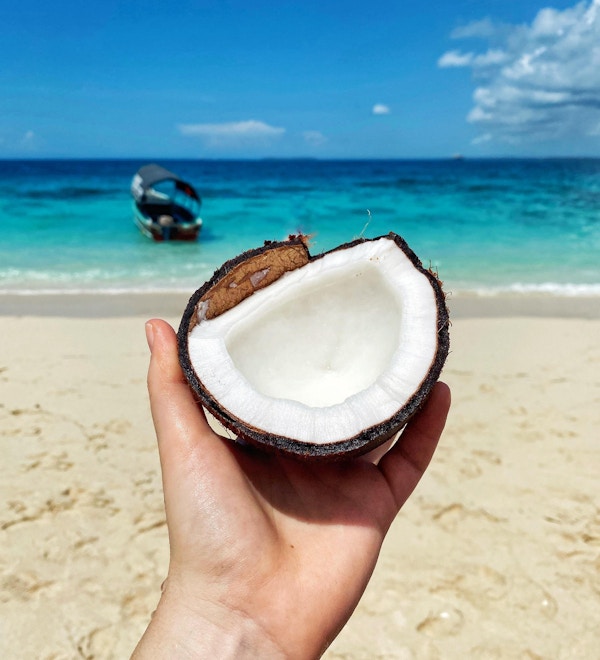 Person holder i en halv kokosnøtt