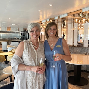 To pent kledd kvinner med hvert sitt glass champagne