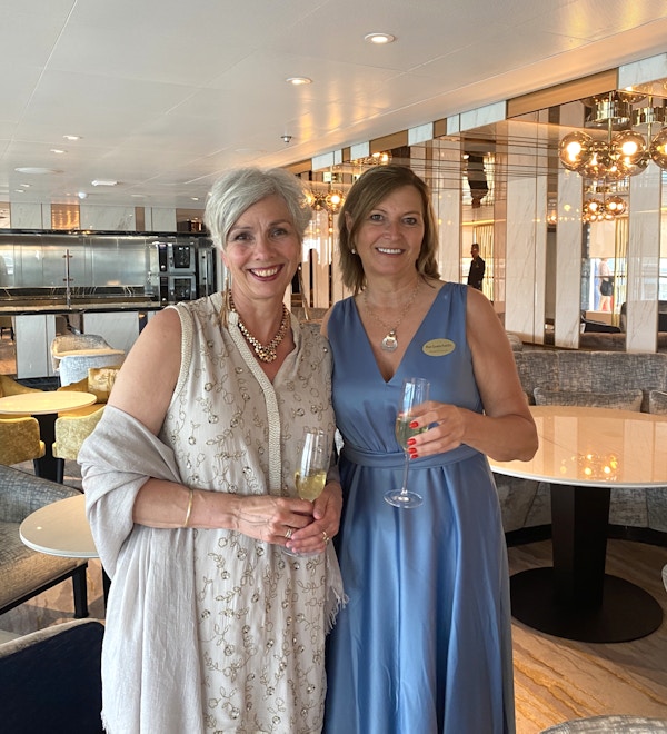 To pent kledd kvinner med hvert sitt glass champagne