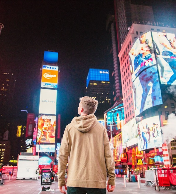Mann står og beundrer lysene på Times Square