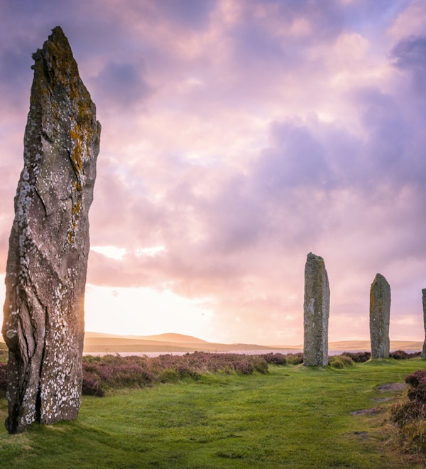 De eldgamle steinene fra Ring of Brodgar på Orknøyene utenfor nordkysten av Skottland, om kvelden like ved solnedgang.