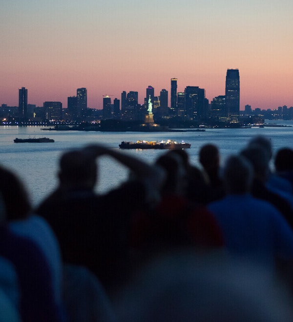En gjeng mennesker ser på og tar bilde av Manhattan skyline