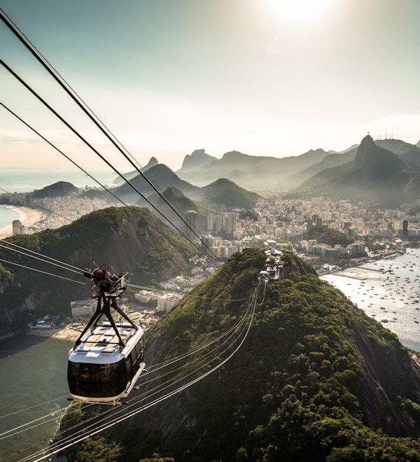 Utsikt over byen Rio de Janeiro fra Sukkertopp-fjellet ved solnedgang med en taubane som nærmer seg.